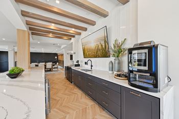 A modern kitchen with dark wood cabinets and a white countertop. at The Concord Luxury Apartments, Sarasota, Florida